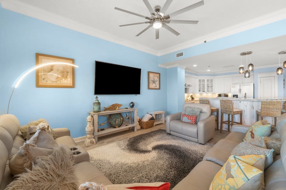Relax in this bright living room with coastal-inspired decor and an open kitchen layout.