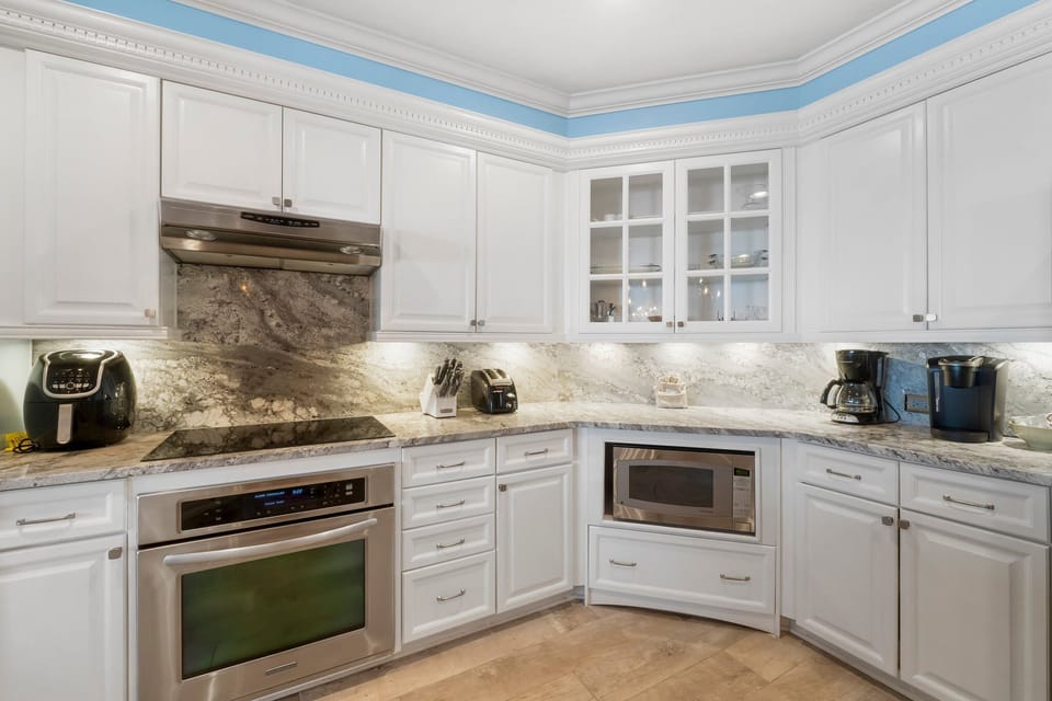 modern kitchen with white cabinetry and marble countertops
