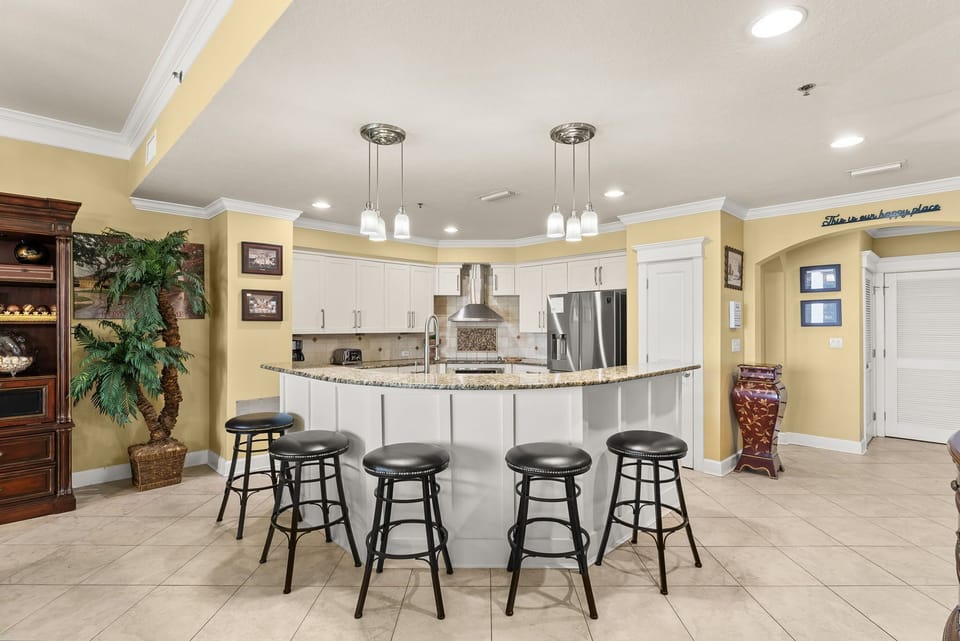 Modern kitchen with a large curved island and seating for five.