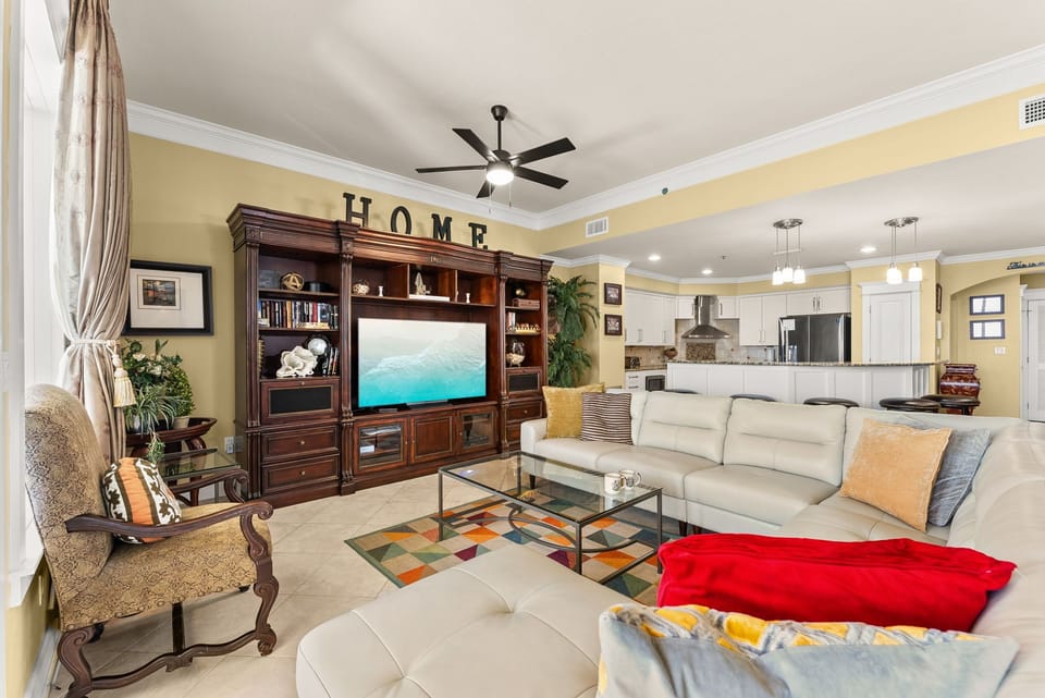 Spacious living room with a large entertainment center and open kitchen layout