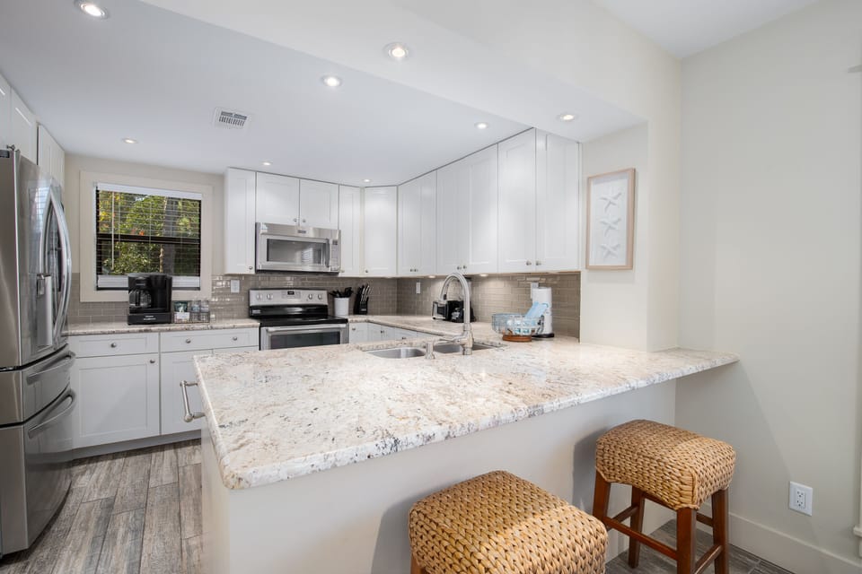Cook your favorite meals in this bright, modern kitchen featuring granite counters, stainless appliances, and a cozy breakfast bar.