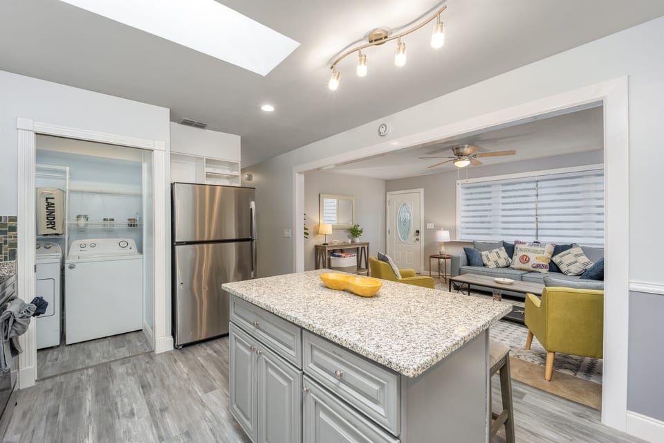 The open concept between the kitchen and dining room provides a simple flow, allowing guests to grab a quick bite to eat or a cold drink from the fridge without missing a moment.