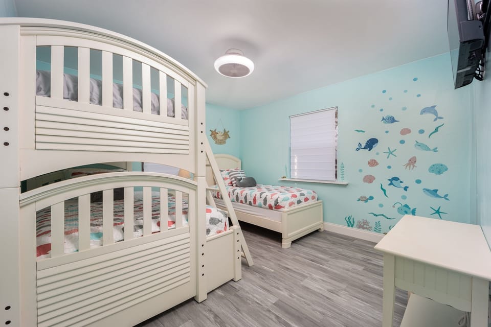 Tuck the kids into their own room, with a curved bunk bed, an extra twin, and ocean-themed decor on the walls.