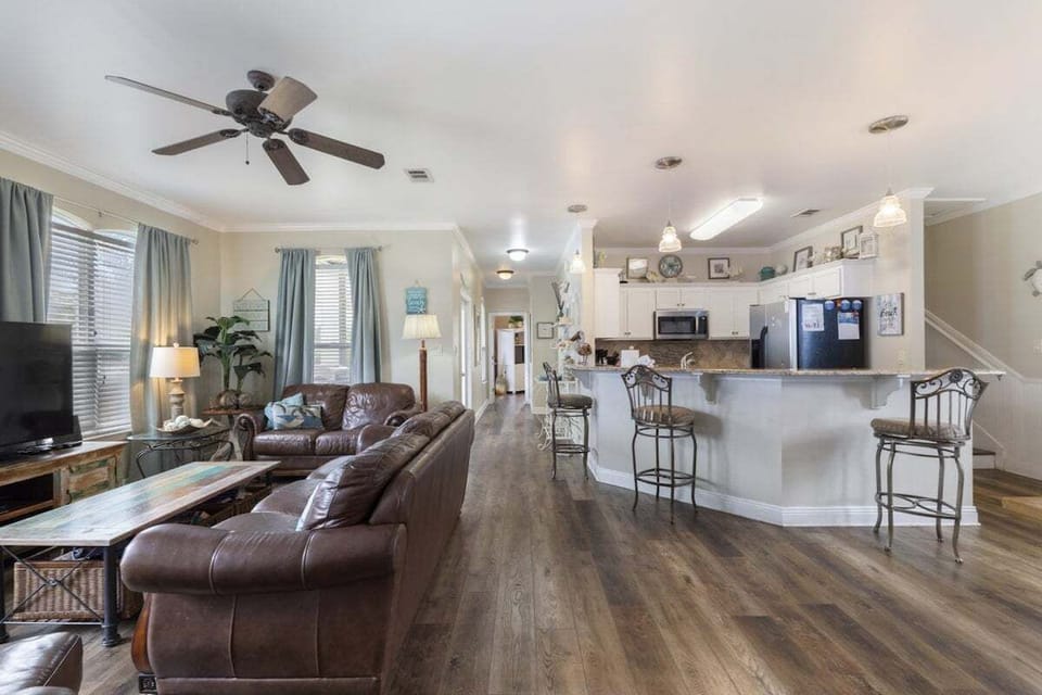 Comfortable living room with leather couches, TV, bar seating and more!!