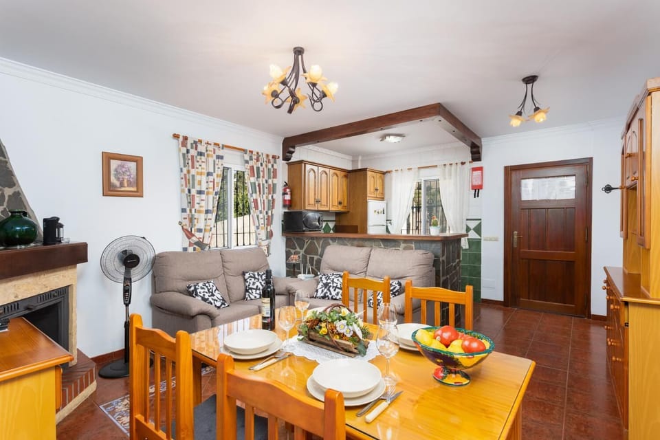 Open-plan living room with sofas, dining area, kitchen, ornamental fireplace, WiFi internet, and satellite TV