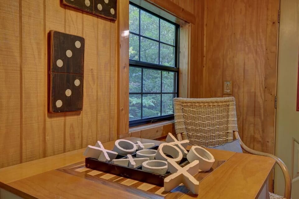 Game room with exterior door, small dog crate, portable safety gate, and doggie bowls.