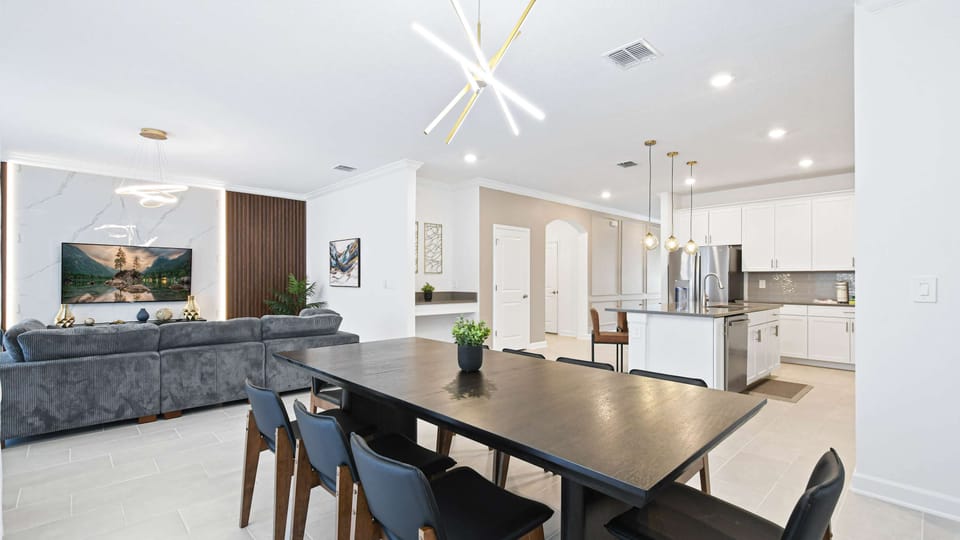 Spacious open-plan dining and kitchen area with modern lighting and elegant style.