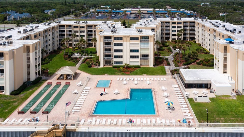 ocean arial view of complex showing heated pool, kiddie pool & shuffle courts