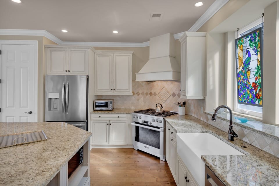 Fully stocked kitchen with stainless steel appliances and 4 barstools for extra seating.