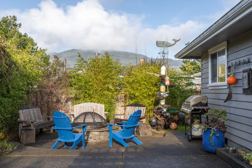 Backyard features a firepit and gas grill.
