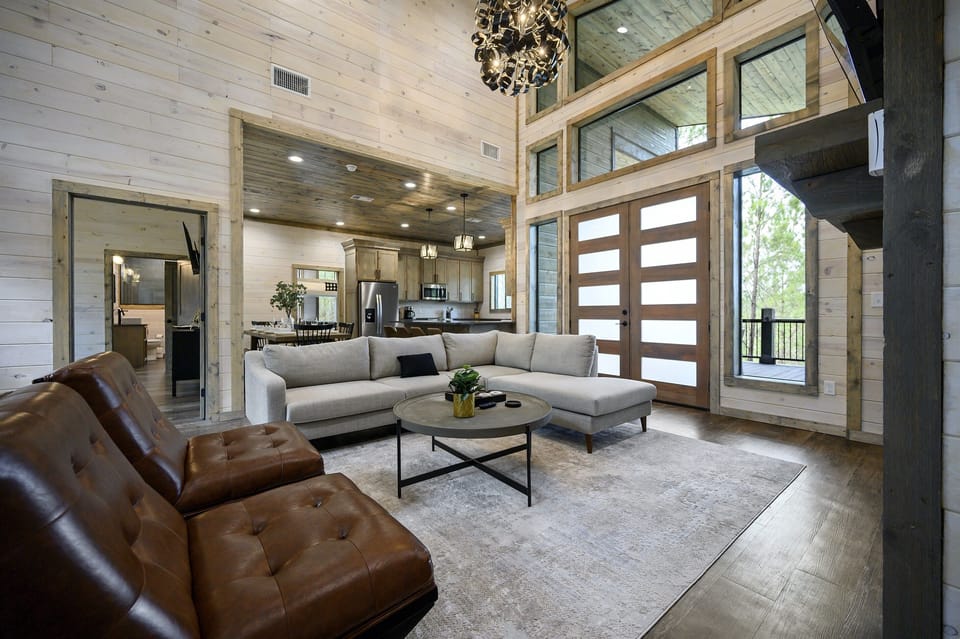 Step into the inviting ambiance of this cabin’s living room, where the beauty of nature seamlessly meets cozy, stylish design 🌲