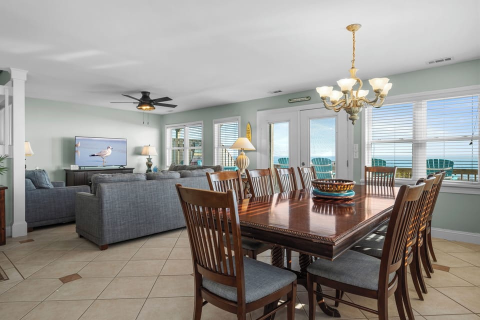 Gather around this elegant dining table where memorable meals await, while ocean breezes flow through your bright, airy retreat.