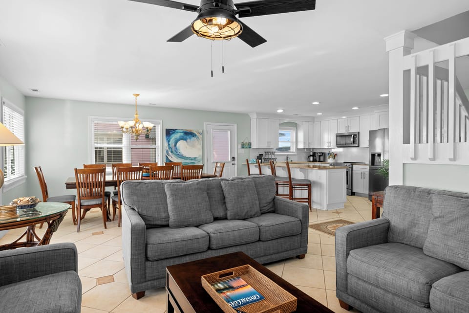 Relax in your spacious open-concept living area with comfortable seating, modern kitchen, and coastal touches throughout.