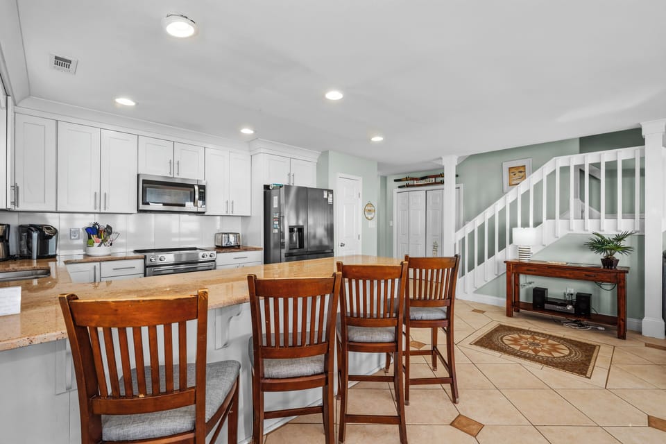 Your spacious kitchen opens to a bright dining area where morning coffee and evening conversations flow naturally together.