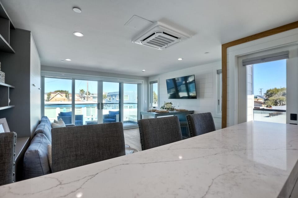 OPEN-CONCEPT KITCHEN OVERLOOKING LIVING AREA & BALCONY – The fully equipped kitchen opens seamlessly into the living area and private balcony, creating a bright, airy layout perfect for entertaining, relaxing, and enjoying indoor-outdoor living during you