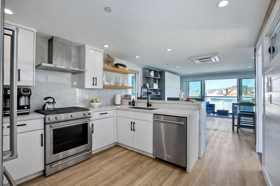 FULLY EQUIPPED KITCHEN WITH BAR SEATING Spacious kitchen with ample counter space and seating for four at the kitchen bar, perfect for morning coffee, casual meals, and gathering together during your Mission Beach San Diego vacation stay.