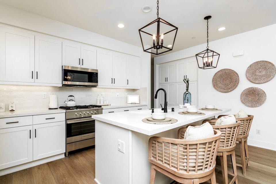 Modern kitchen w/ island seating, pendant lights & stainless appliances