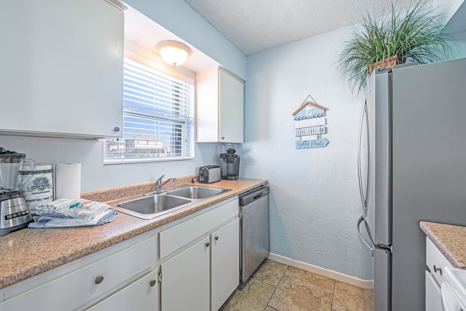 Your fully equipped kitchen awaits with granite counters, stainless appliances, and cheerful coastal touches to inspire memorable meals.