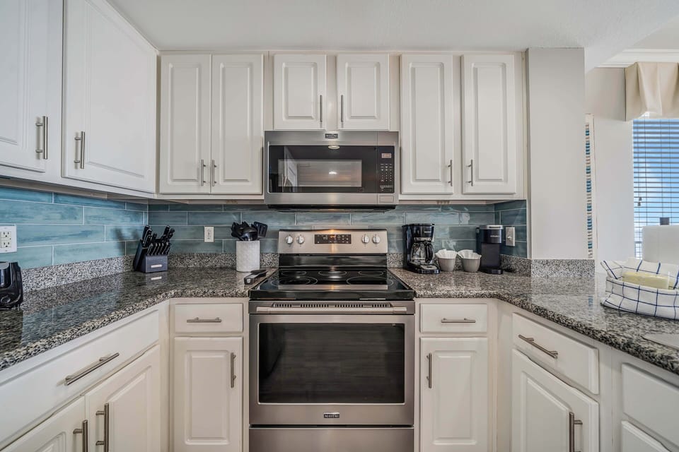 The fully equipped kitchen features granite countertops, stainless-steel appliances, and everything you need to cook meals for family and friends.