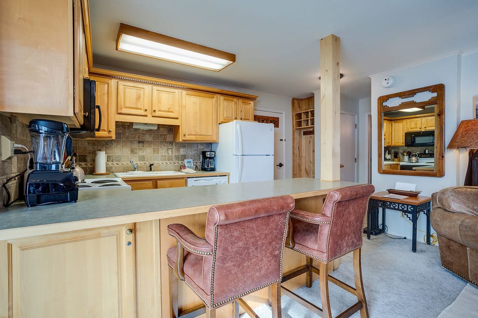 Gather around your spacious kitchen island with warm wood cabinetry and stone backsplash, perfect for morning coffee or evening conversations.