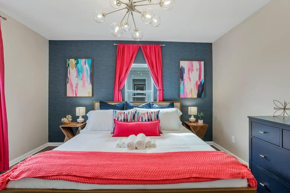 Bedroom 2 on the second floor: a king memory foam bed, calm blue walls, a 55 inch Roku TV and a white noise machine for deep sleep after a big game day.
