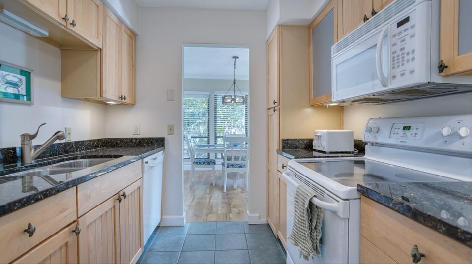 Thoughtful layout keeps everything within reach, with an opening to the dining area that brings in natural light.