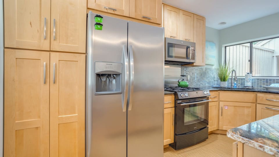 A built-in beverage fridge and convenient small-appliance station add function and ease, creating a bright, thoughtfully designed area.