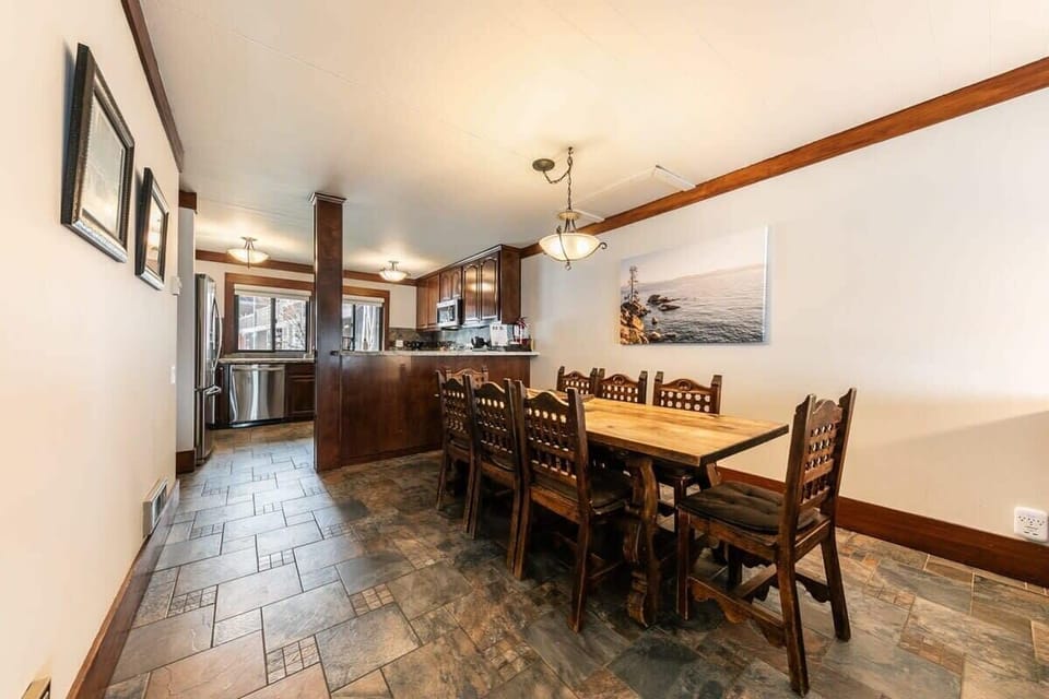 The large dining area features a long wooden table that can seat up to 8 of your friends and family.