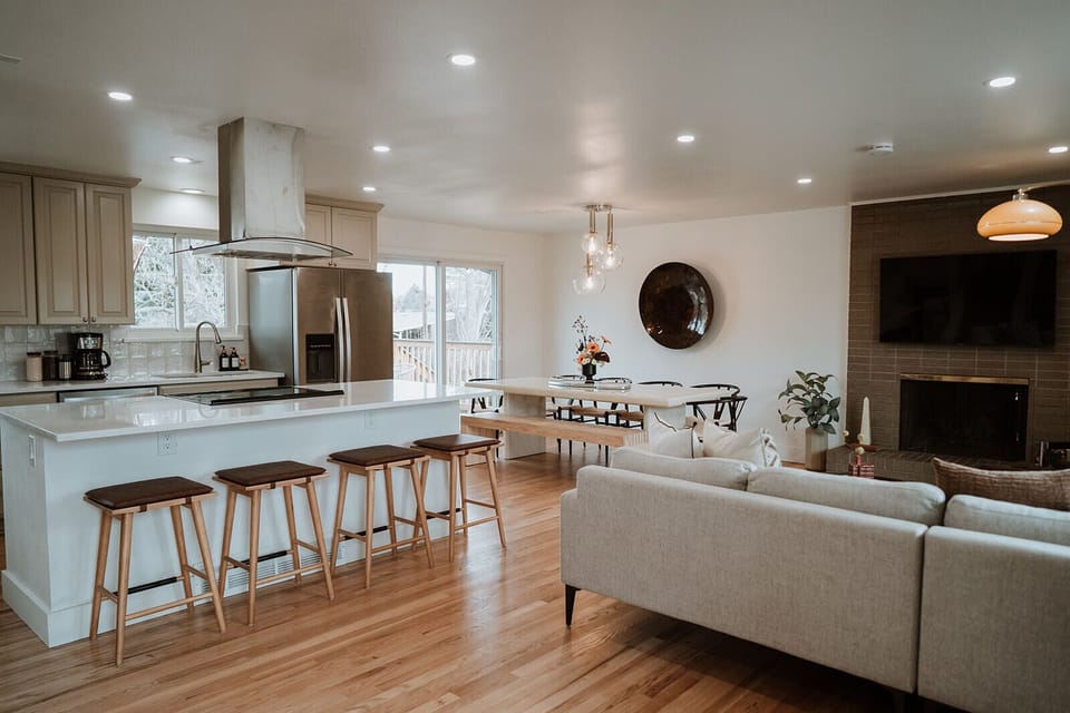 - Bright open layout with a full kitchen, island seating, and cozy dining nook
- Enjoy meals with natural light and views through sliding glass doors
- Relax in the living area with fireplace ambiance and modern decor throughout