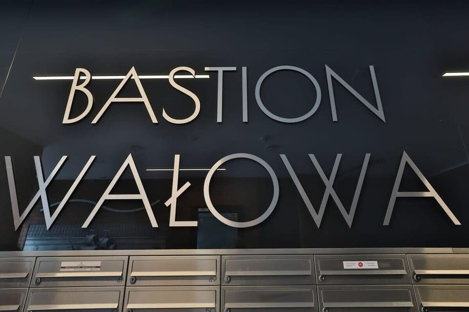A close-up of the "Bastion Wałowa" sign, showcasing the name of the building with modern typography and elegant design.
