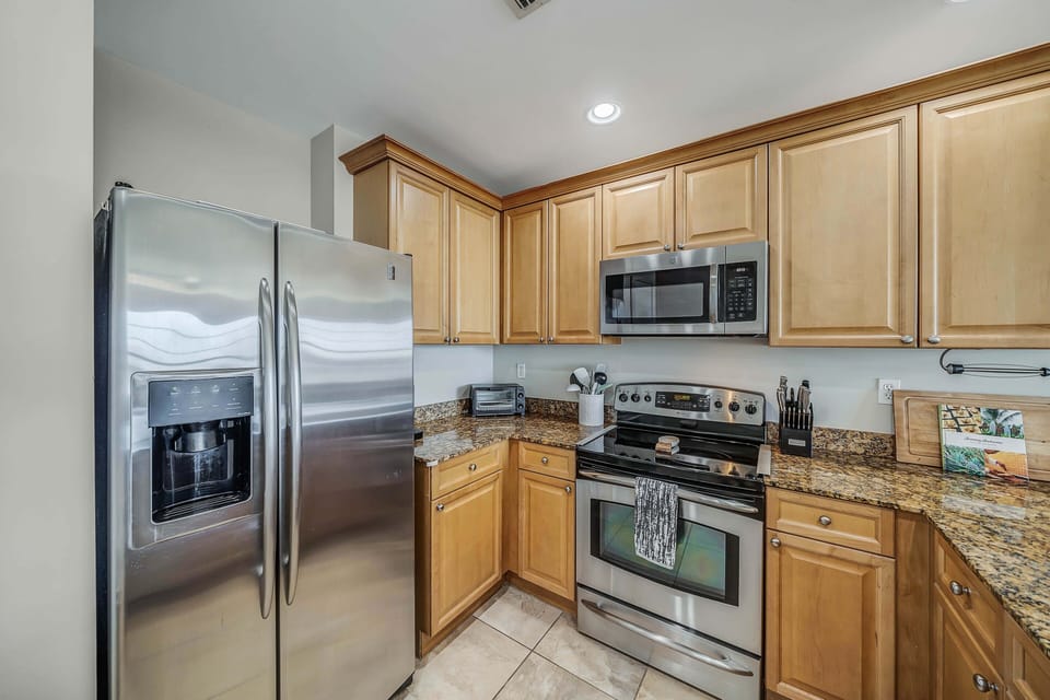 The fully equipped kitchen features granite countertops, stainless-steel appliances, and has everything you need to enjoy meals with family and friends.