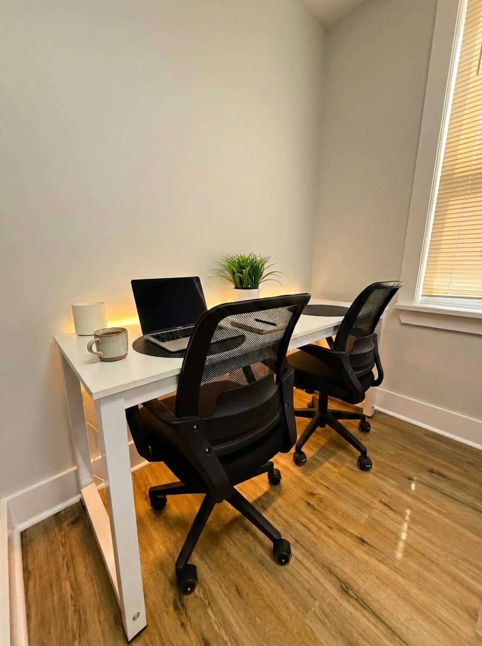 Dedicated workspace with desk, two office chairs, and window light.