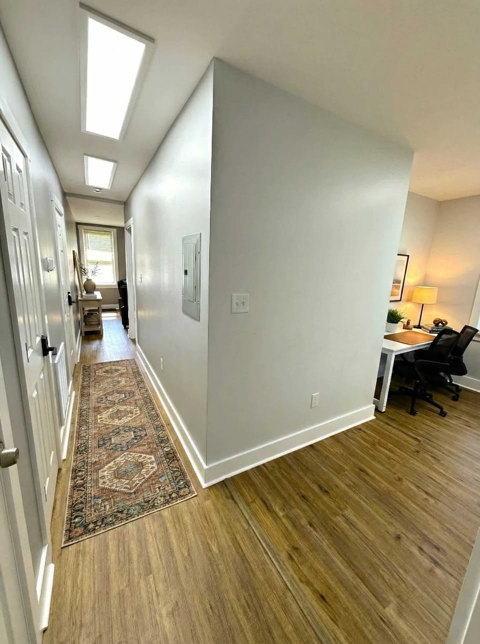 Hallway view with closet storage and workspace nook at the end.