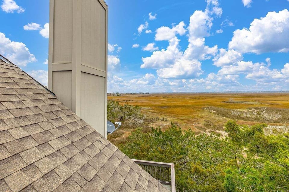 Rooftop marsh views with blue sky and clouds