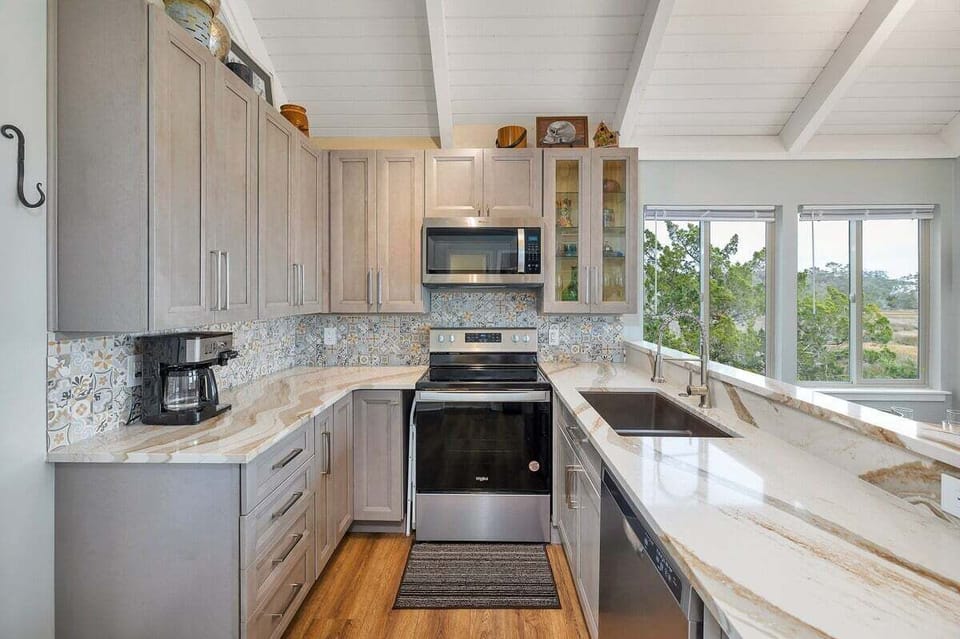 Kitchen with gray cabinets, stainless appliances, and marsh views