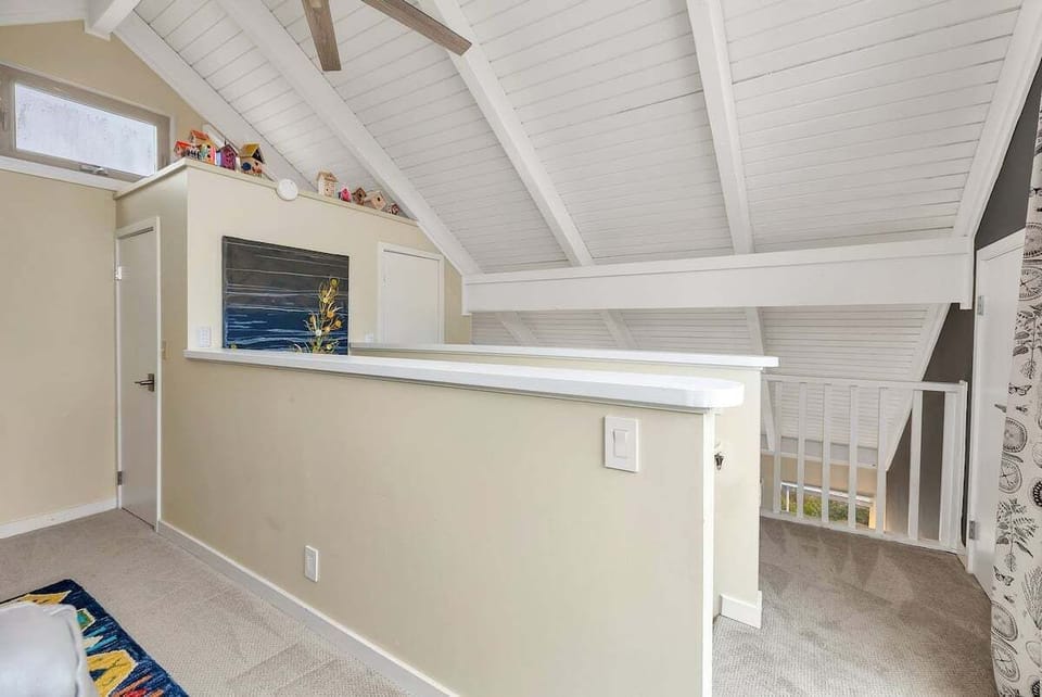 Loft landing with vaulted ceiling and open railing