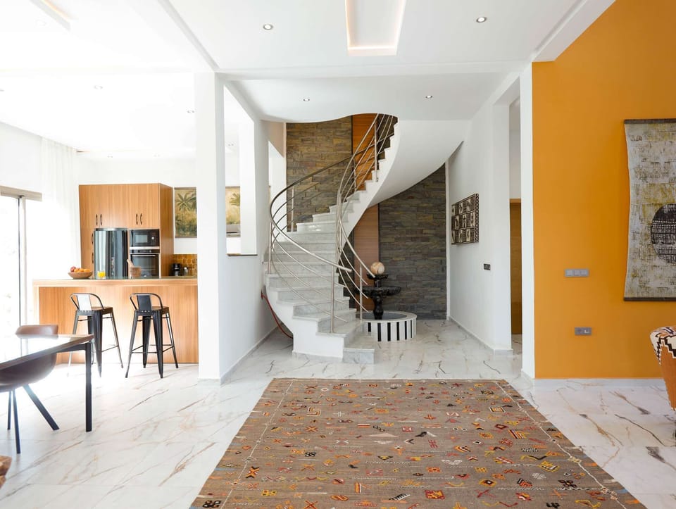 Bright, thoughtfully designed ground floor featuring an expansive handmade Moroccan rug, an open-plan layout, and curated wall art.
