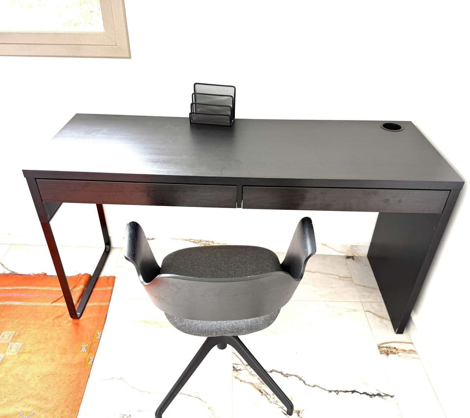 Quiet ground-floor office with desk and comfortable chair—ideal for private meetings or focused work away from the main living areas.