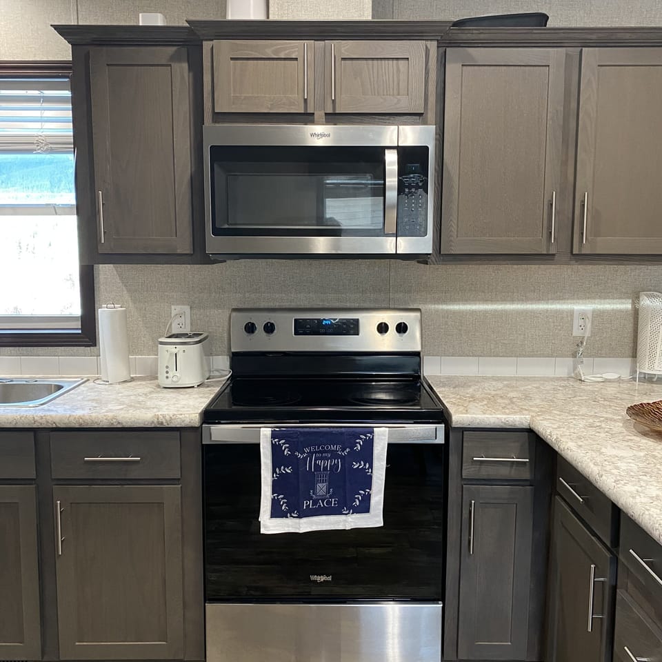 Fully equipped kitchen with stove, microwave, and all cookware & utensils.