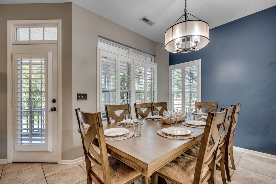 Gather 'round for coastal feasts! Our solid wood dining table, seating 8, invites you to savor moments and meals with an ocean breeze. Enjoy the view of the screened-in porch—a perfect setting for family dinners with a side of sea breeze.