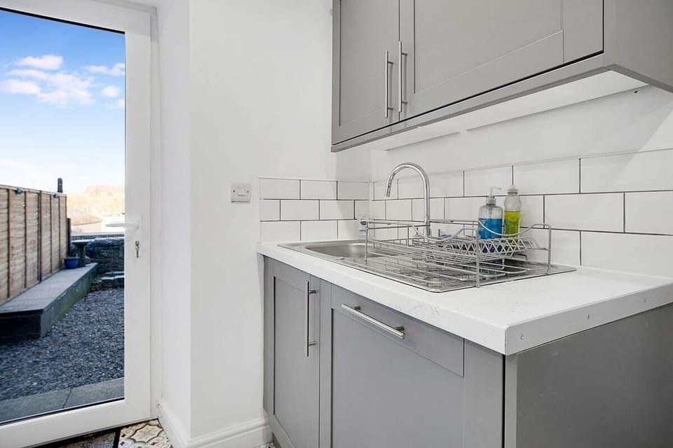 Kitchen equipped with all essentials, including a washer & dryer, oven, fridge, dishwasher and full cookware set.