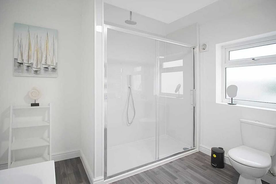 The bathroom benefits from a bath, an overhead shower, toilet and a sink. 