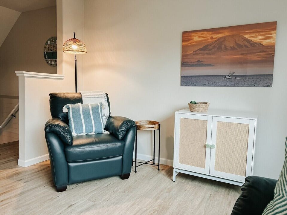 This leather chair in the living room looks out the big back-facing window and would be a great place to sip your coffee or read with the nearby lamp.