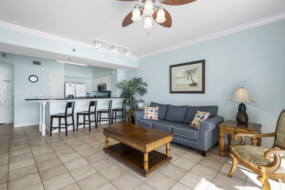 Open living area with coastal-inspired decor and a breakfast bar seating four.