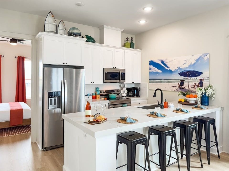 The fully stocked kitchen has 4 additional bar seats by the island.