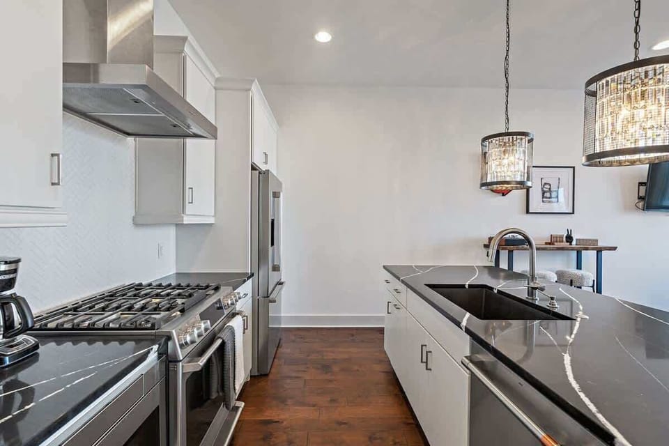 Spacious modern kitchen with black marbled island and white cabinets