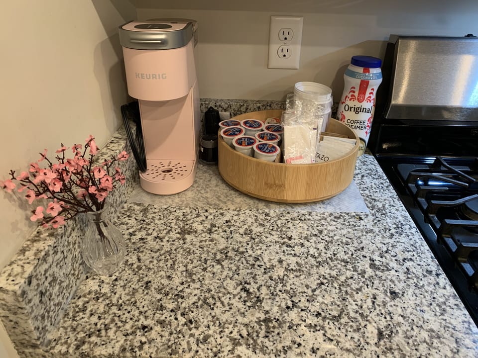 Coffee and Tea corner with coffee pods, tea bags, cups with lid, creamer+suger