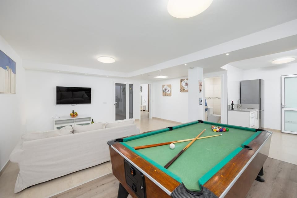 Living area with sofa, kitchenette, pool table, WiFi internet, and satellite TV