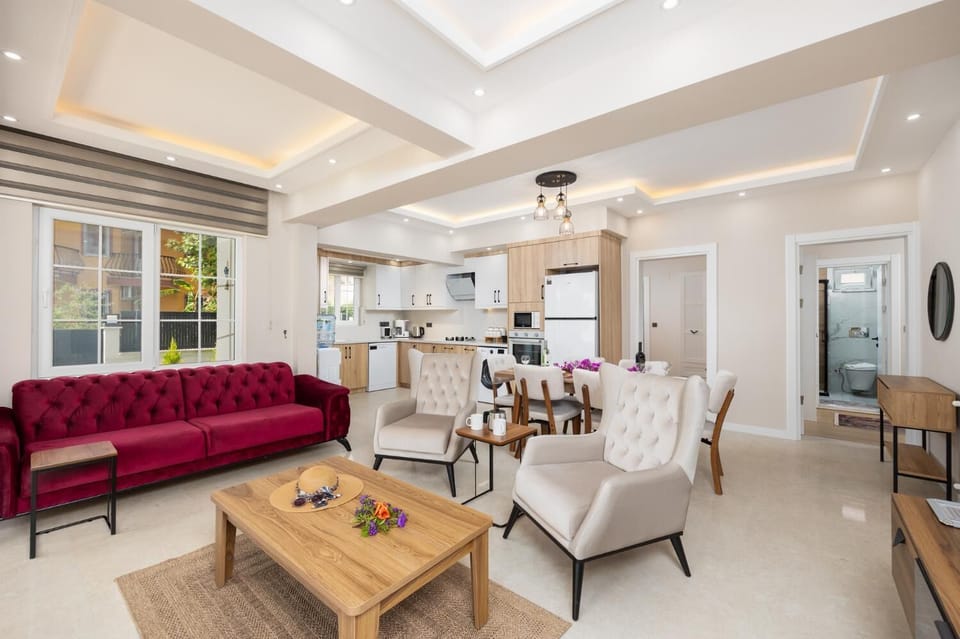 Open-plan living room with sofa, dining area, kitchen, A/C, WiFi internet, and satellite TV
