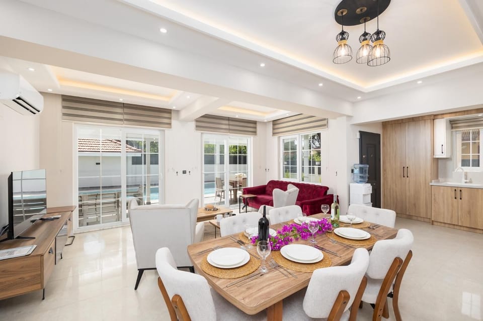 Open-plan living room with sofa, dining area, kitchen, A/C, WiFi internet, and satellite TV